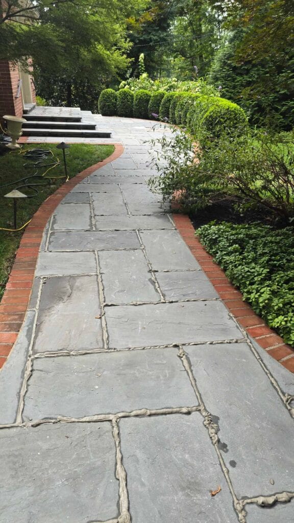 Stone pathway with brick edges from a Rose Restoration job in Bethesda, MD