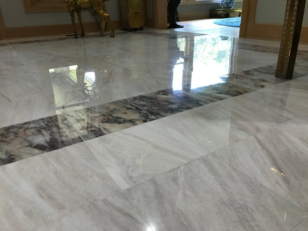 White marble floor with a dark marble border in a home