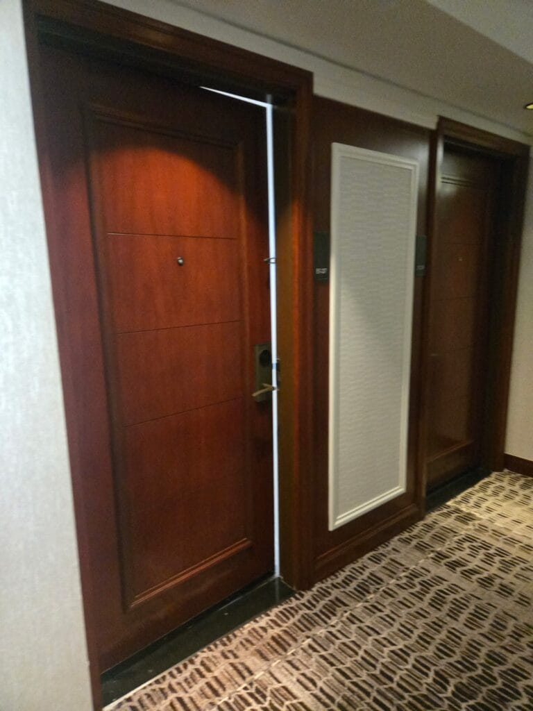 Why Hotel Corridor Doors Fail First (And What Refinishing Them Involves)