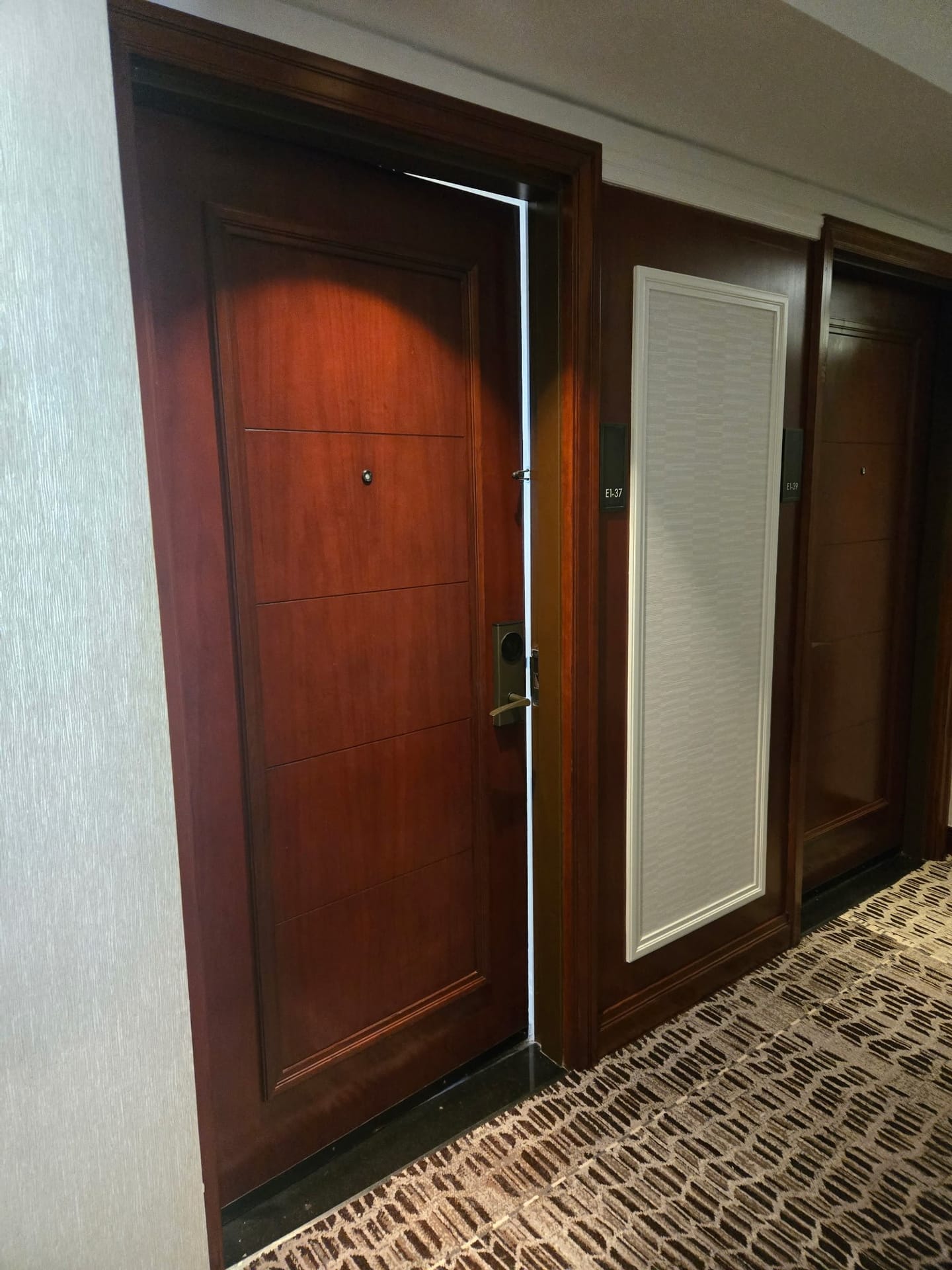 Refinished wood guest room door in a hotel corridor, restored in place by Rose Restoration