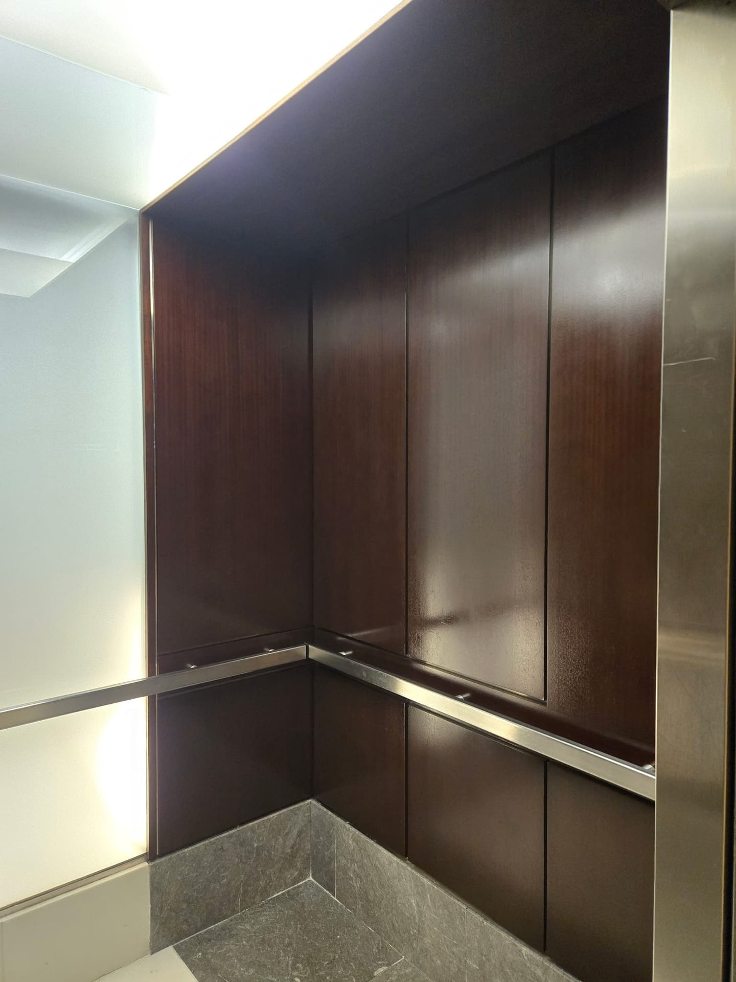Warm wood elevator cab interior after panel refinishing by Rose Restoration