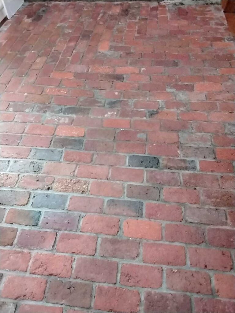 After: the same brick floor in a historic cabin in Chevy Chase, MD after Rose Restoration's work