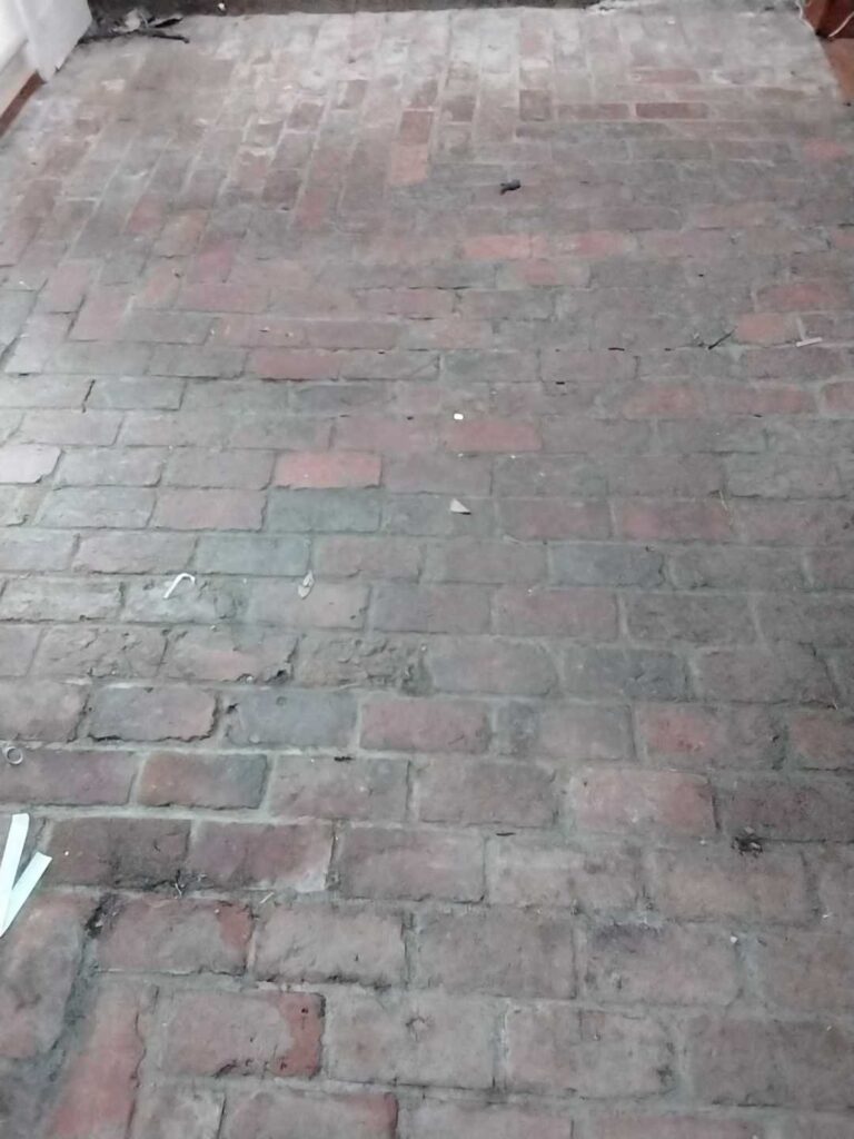 Before: brick floor in a historic cabin in Chevy Chase, MD, photographed by Rose Restoration before the work