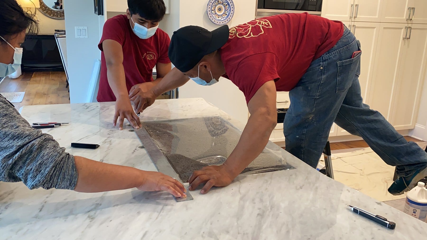 Crew aligning Marble Armor film on a marble surface