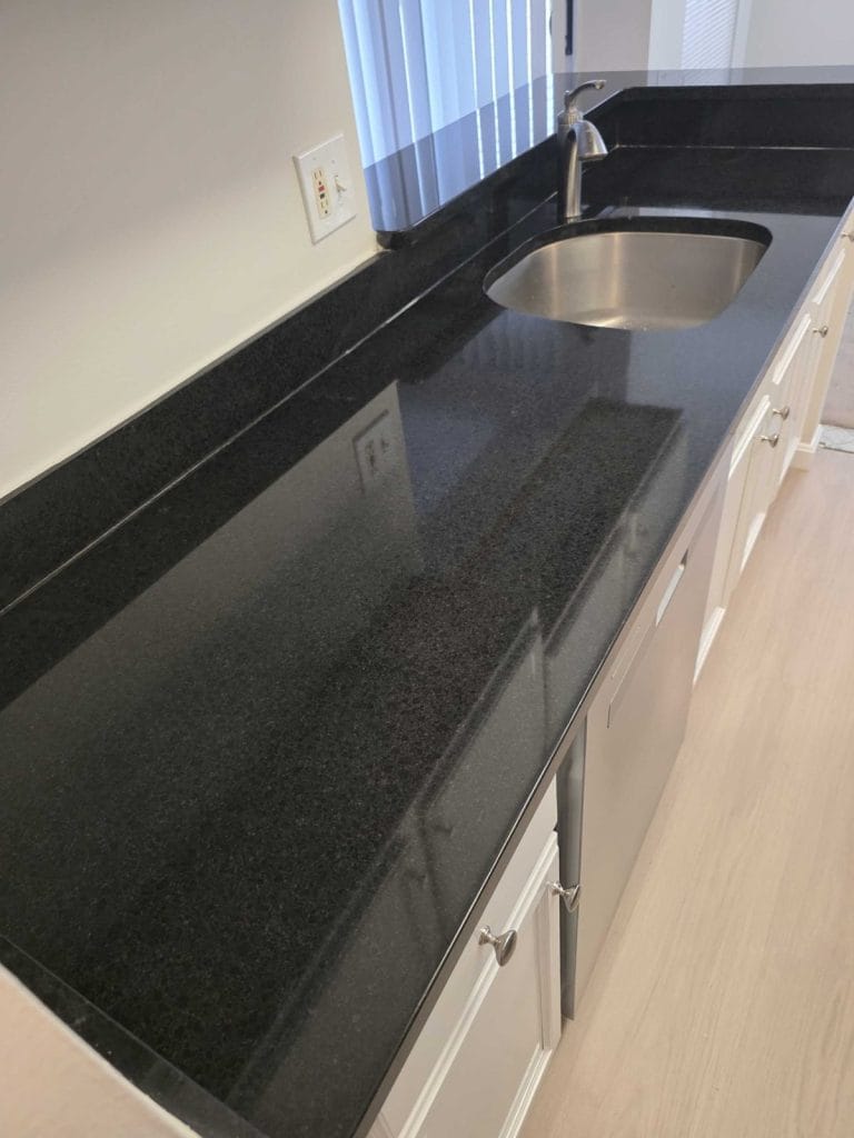 Dark granite countertop with an even polished finish after restoration in Reston, VA