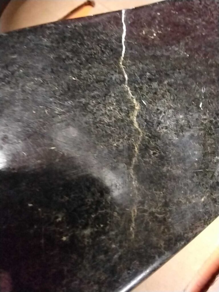 Dark stone sculpture with a crack, Rose Restoration project