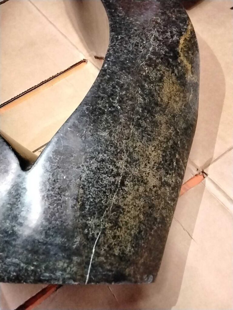 Dark stone sculpture with scratches and stains, Rose Restoration project