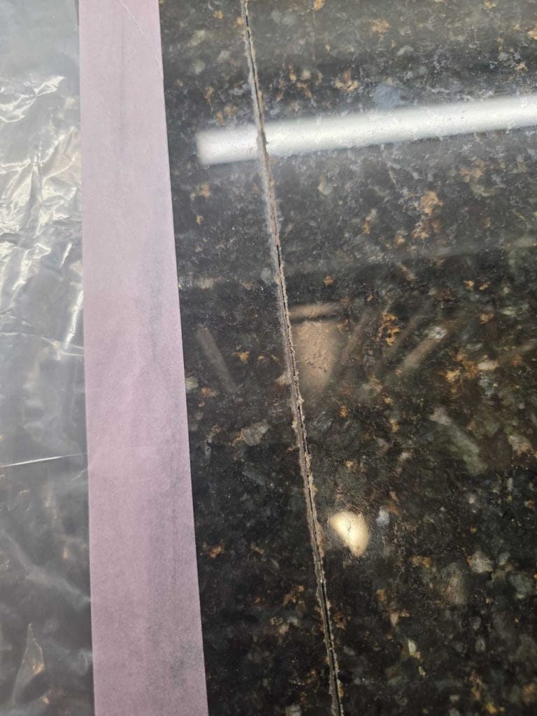 Granite countertop seam masked off for repair in Alexandria, VA