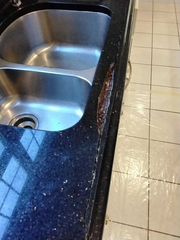 Before: cracked granite at a kitchen sink in Silver Spring, MD, photographed by Rose Restoration before the work