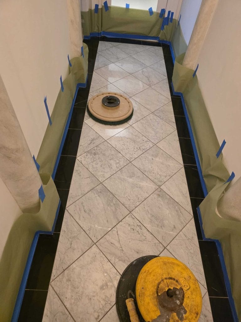 Marble hallway masked off with a floor machine during restoration in a Washington, DC apartment
