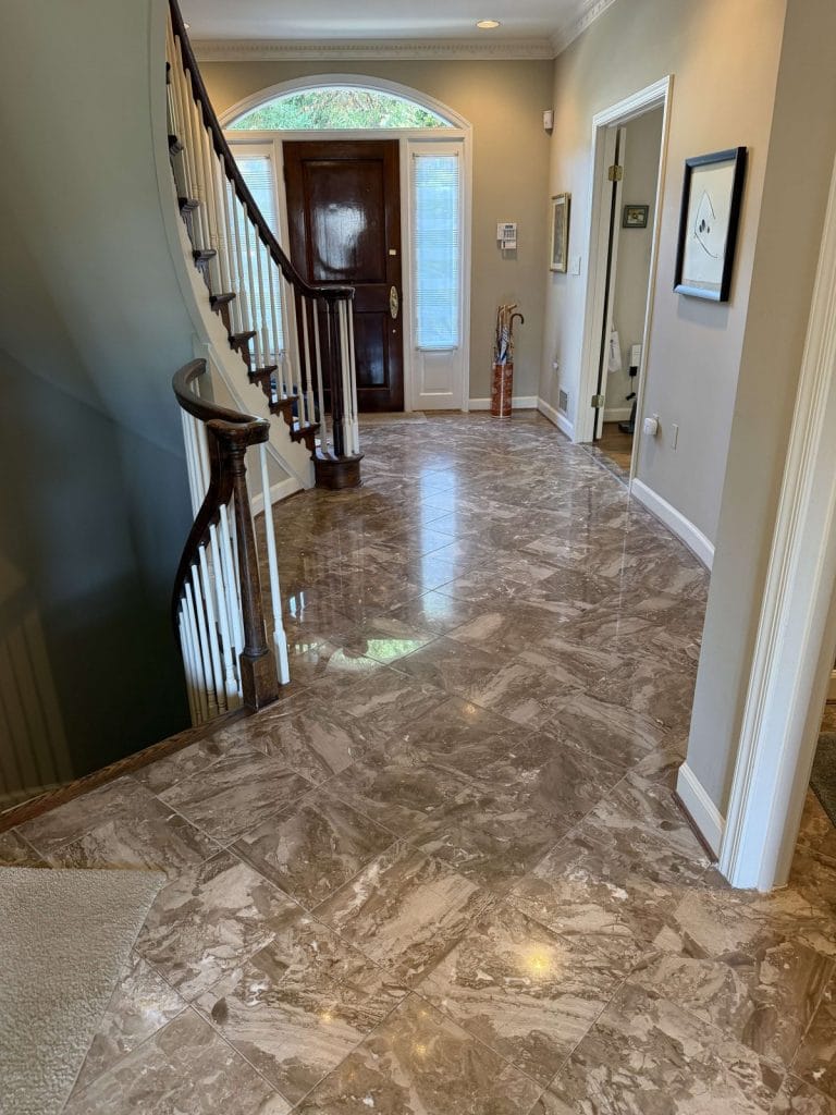 Polished marble foyer floor beside a curved staircase in a Georgetown home