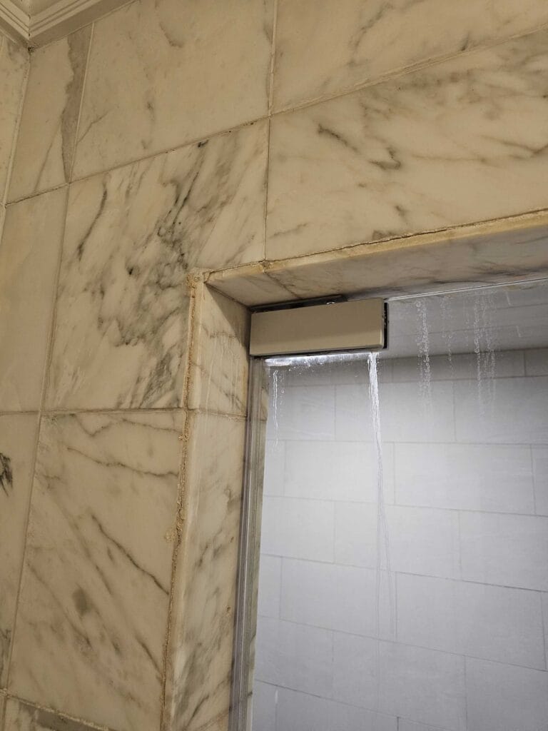 Marble wall with glass shower door from a Rose hotel job in McLean, VA