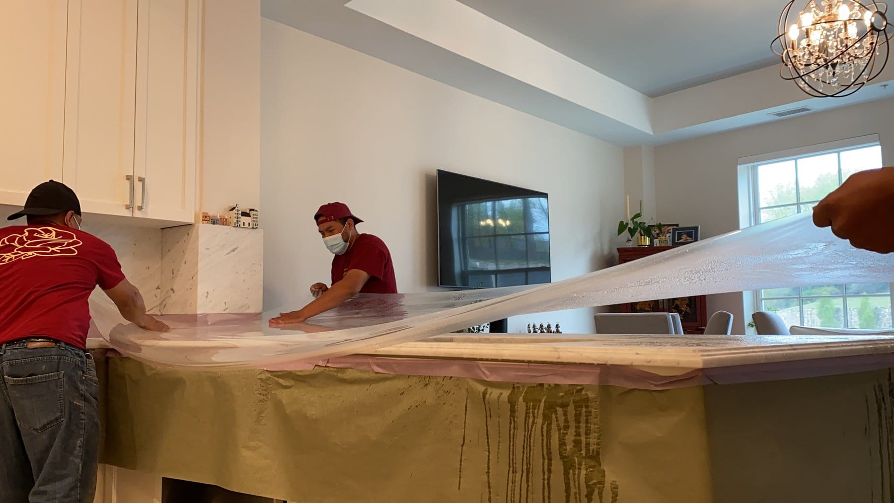 Rose crew stretching Marble Armor film over a countertop