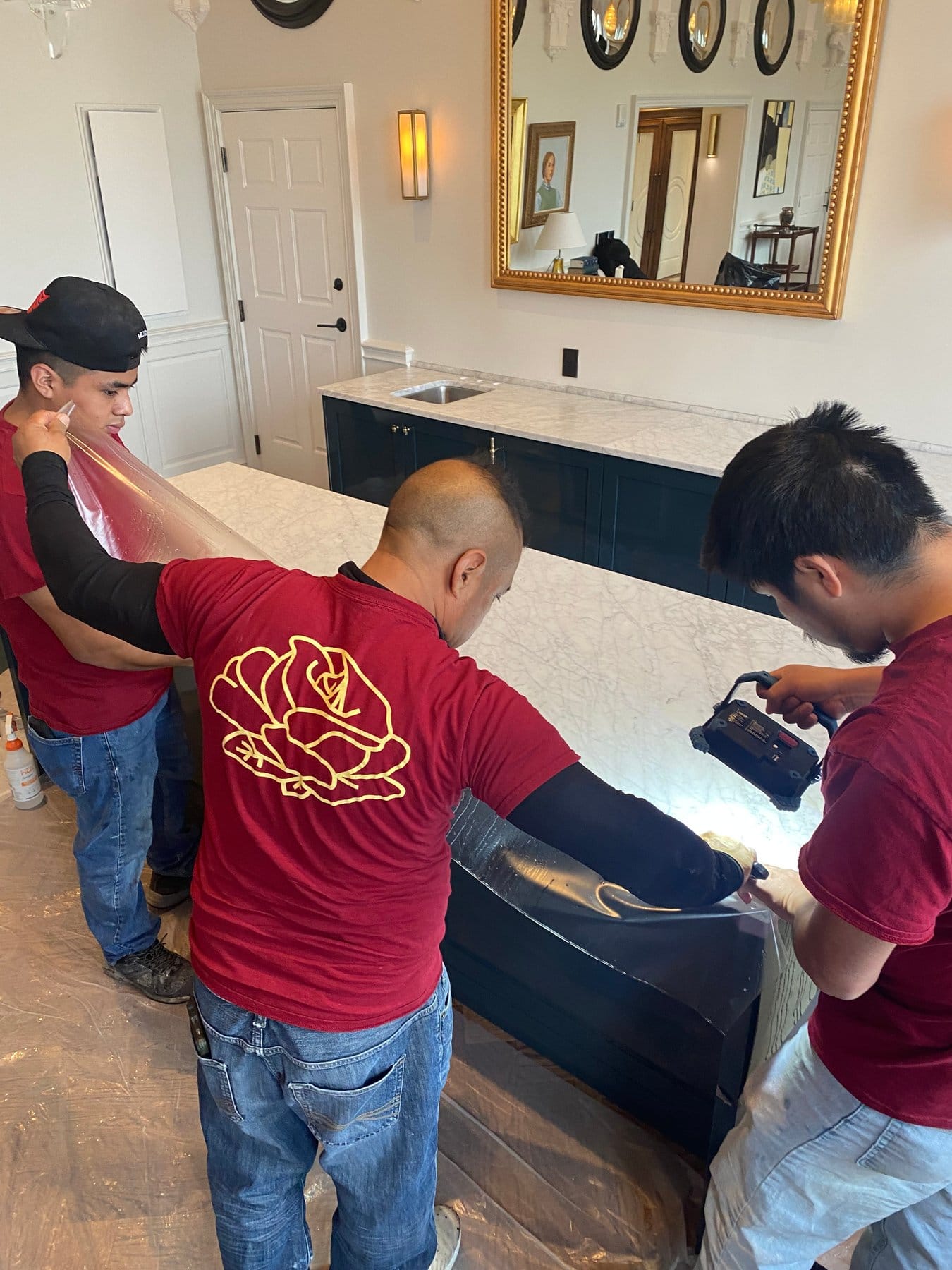 Rose crew trimming Marble Armor film on a dark countertop