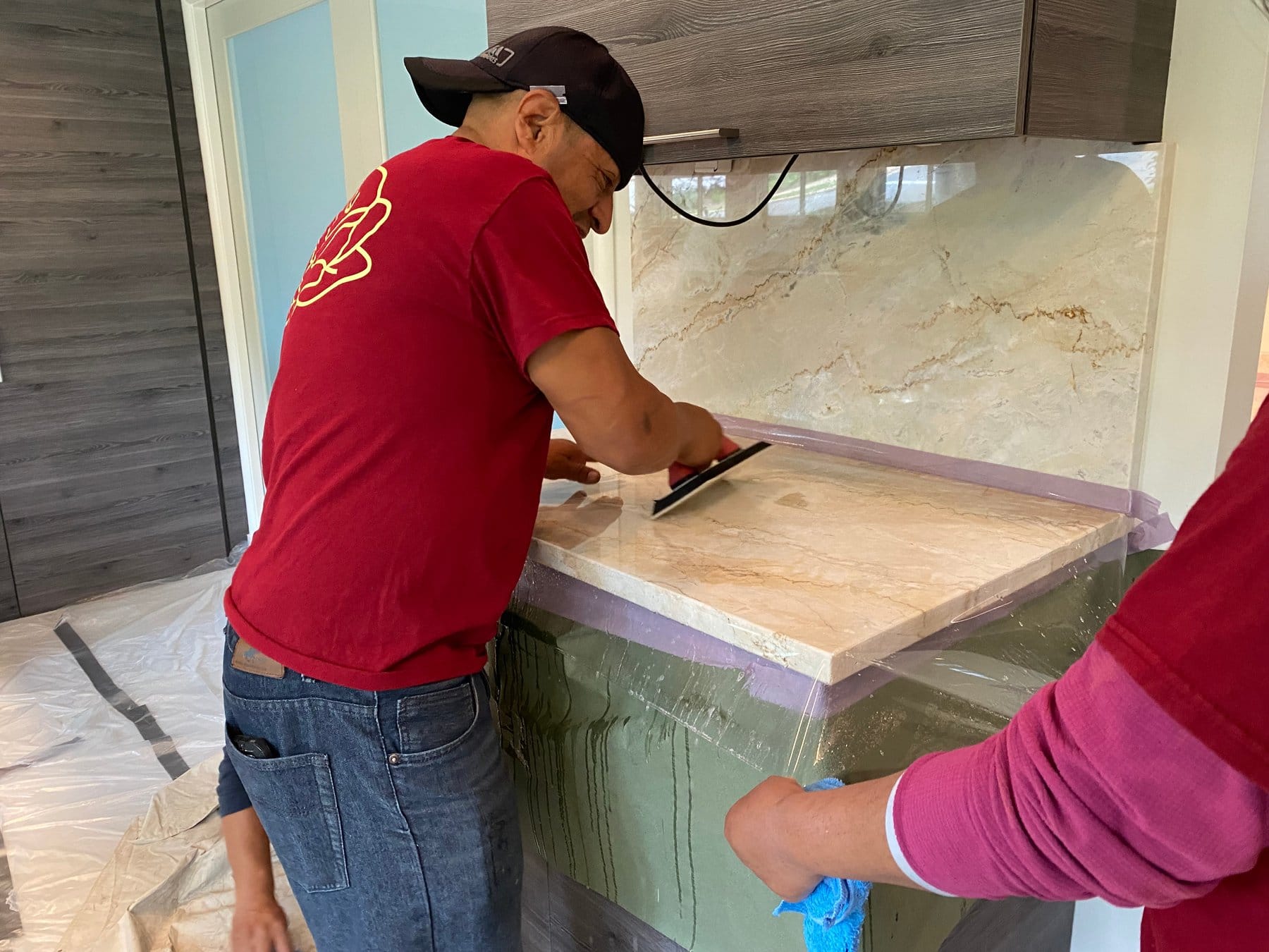 Squeegeeing Marble Armor film onto a stone countertop