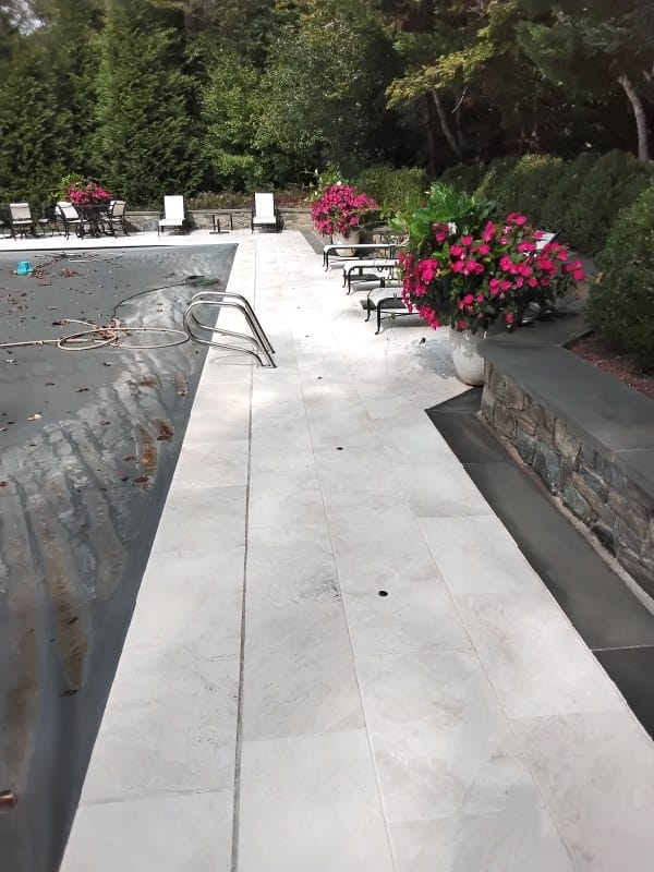 Stone patio beside pool from a Rose job in Clifton, VA