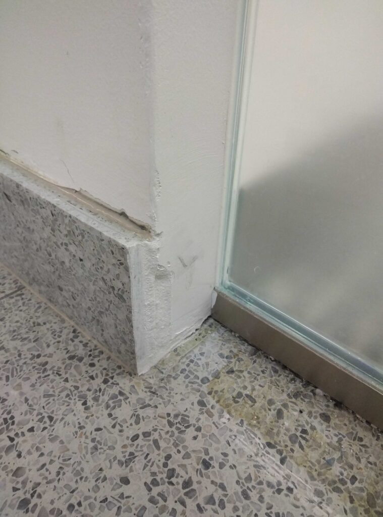 Before: terrazzo base at a shower in Silver Hill, MD, photographed by Rose Restoration before the work