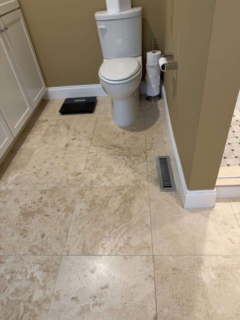 Travertine bathroom floor before grinding and restoration in Locust Grove, VA