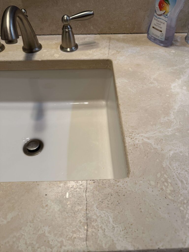 Before: travertine vanity top in Oakton, VA, photographed by Rose Restoration before the work