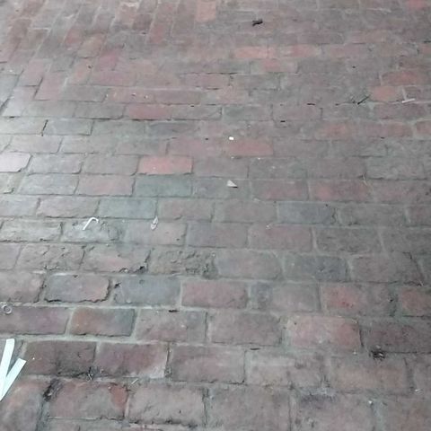 Brick floor in a historic cabin before restoration