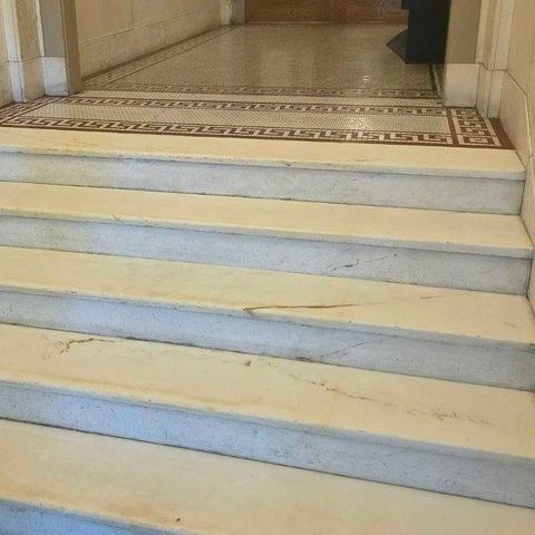 The same marble lobby stairs and Greek key border after restoration by Rose Restoration, treads clean and even