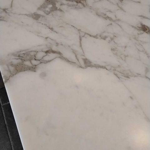 The same white veined stone kitchen island in Bethesda, MD after Rose Restoration's work: etch removed and the polish evened out