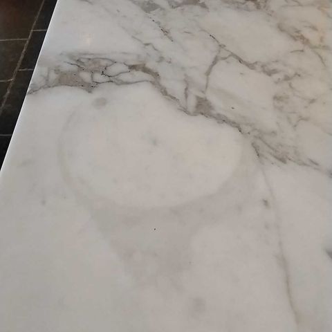 White veined stone kitchen island in Bethesda, MD before Rose Restoration's work: a dull etched ring on the surface